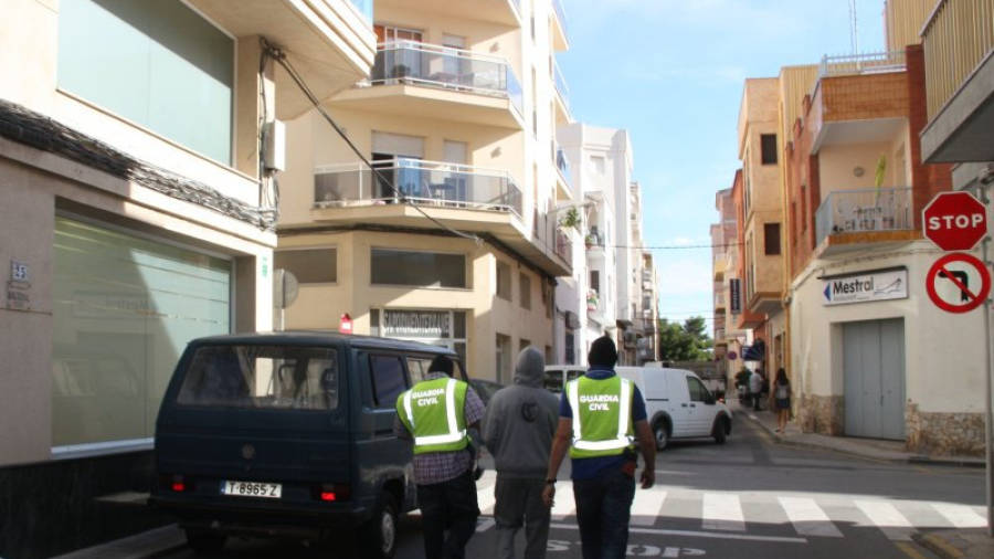 Dos agents de la Guàrdia Civil emportant-se a un dels detinguts en el registre del carrer Cervantes de l'Ametlla de Mar. FOTO: ACN