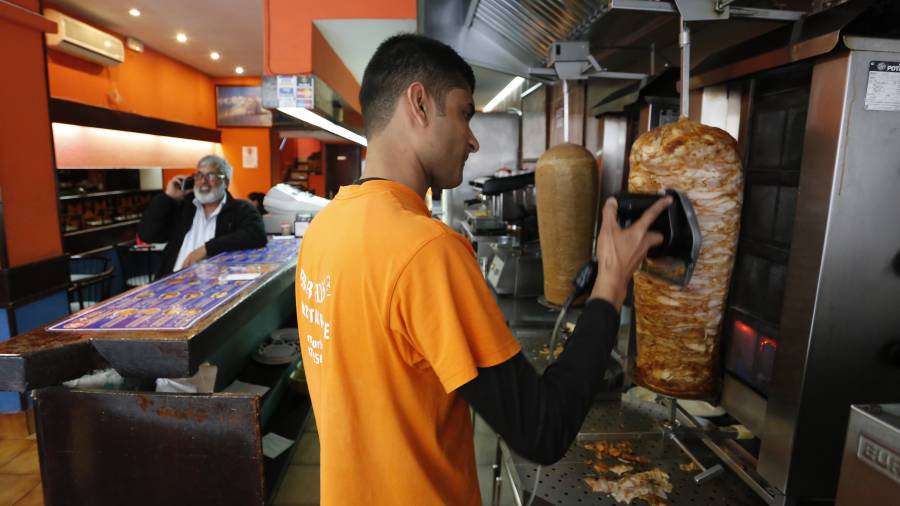 El joven Saqib, trabajando en Kebab House, un establecimiento que lleva diez aÃ±os abierto en Pere Martell. FOTO: PERE FERRÃ‰