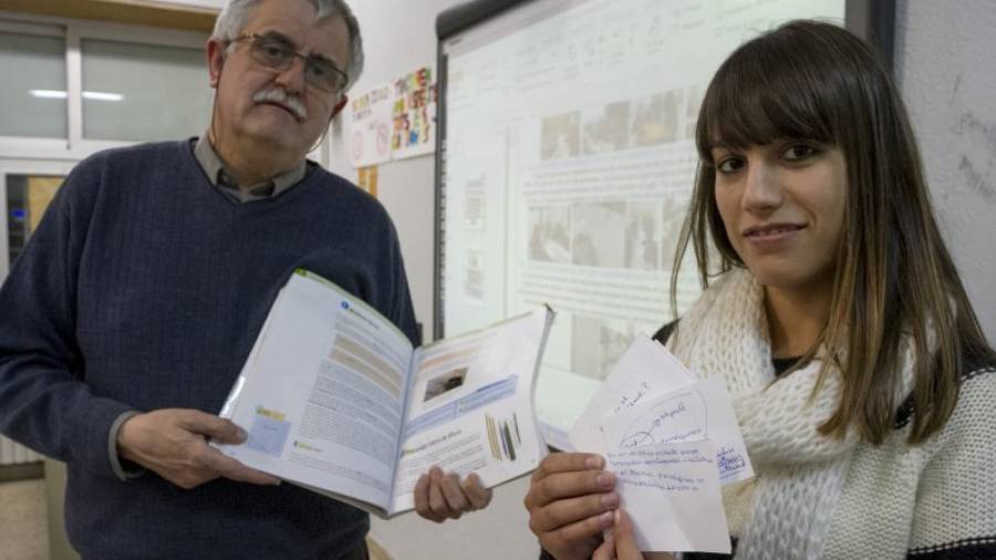 Josep Maria Ferran enseña, junto a una alumna, las fichas que están preparando para un juego. Foto:Pere Ferré