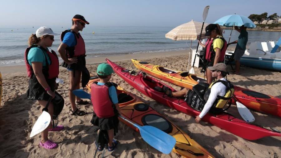 Un grupo de visitantes, a punto de practicar kayak en la playa. Foto: Pere Ferré
