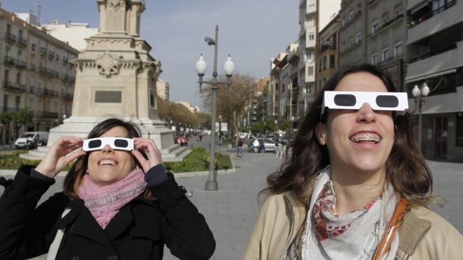 Dues noies contemplen l'eclipsi a Tarragona amb ulleres especials. Foto: Pere Ferré