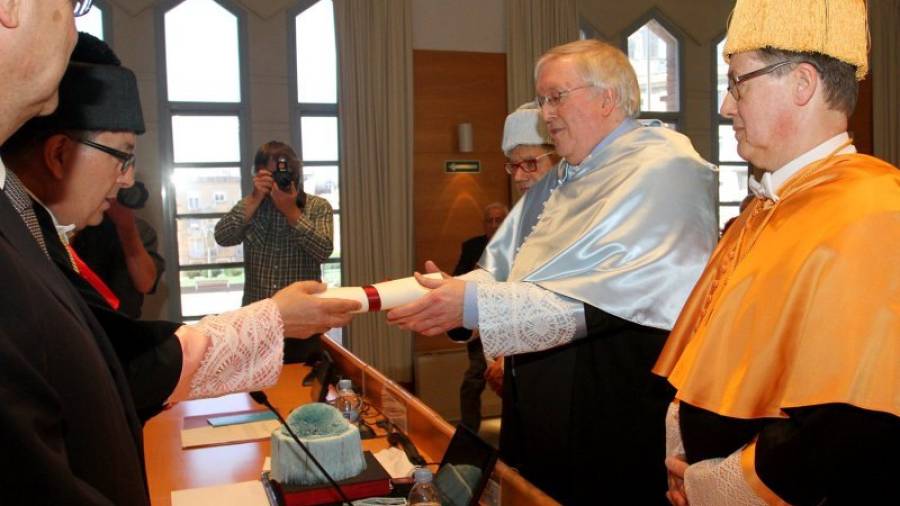 Preston, al lado de sus padrinos, recibiendo el título de la mano del rector Josep Anton Ferré. Foto: Lluís Milián