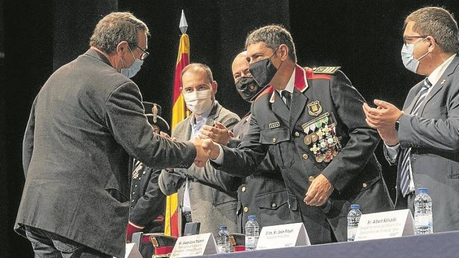 Un dels tres mossos jubilats darrerament rebent de mans del major Josep Lluís Trapero una credencial petita. Foto: Joan Revillas