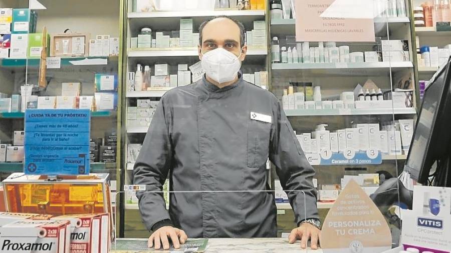 Jordi tras el mostrador de la Farmacia de guardia. FOTO: Pere Ferré
