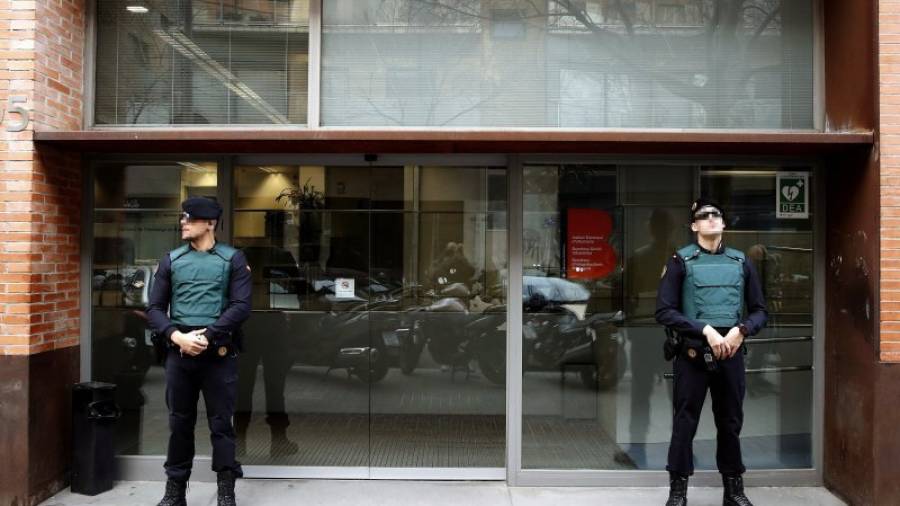 Agentes de la Guardia Civil custodian la entrada de la sede de Bimsa (Barcelona d'Infraestructures Municipals SA) durante el el registro llevado a cabo en el marco de una operación contra la supuesta financiación irregular de Convergè