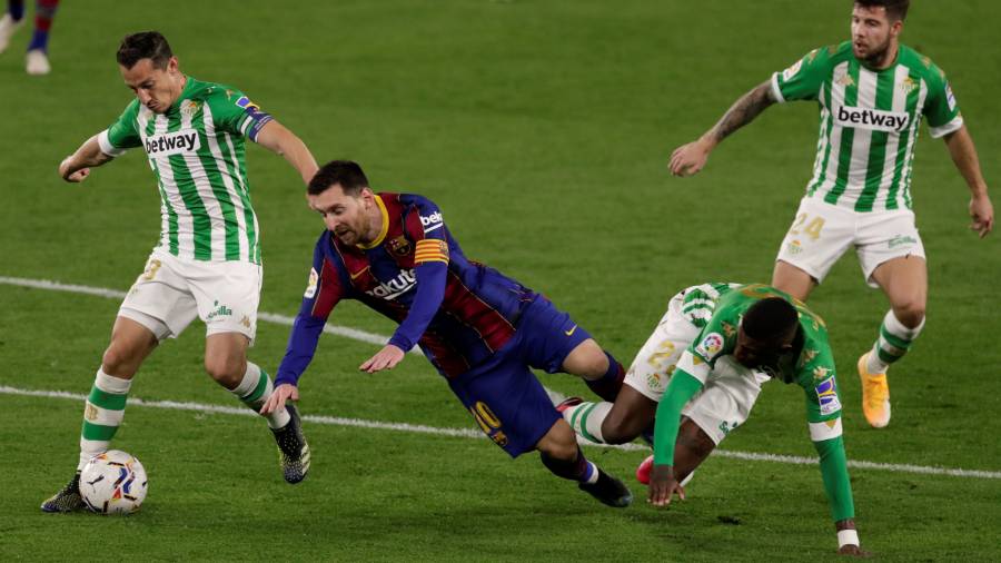 Messi cae después de la entrada de un jugador del Betis. FOTO: EFE