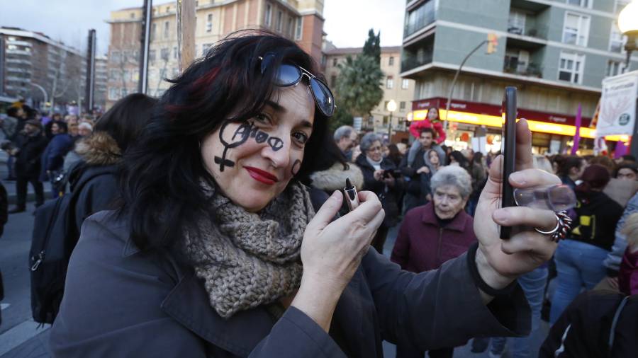 Una mujer se pinta el s&iacute;mbolo femenino en el rostro, durante el inicio de la manifestaci&oacute;n, en la Imperial Tarraco. FOTO: Pere Ferr&eacute;