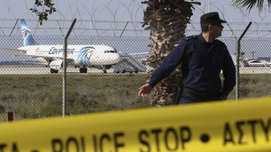 Un policía monta guardia cerca del avión de Egiptair secuestradoo por un pasajero con un cinturón explosivo en el aeropuerto de Larnaca (Chipre). EFE/Katia Christodoulou