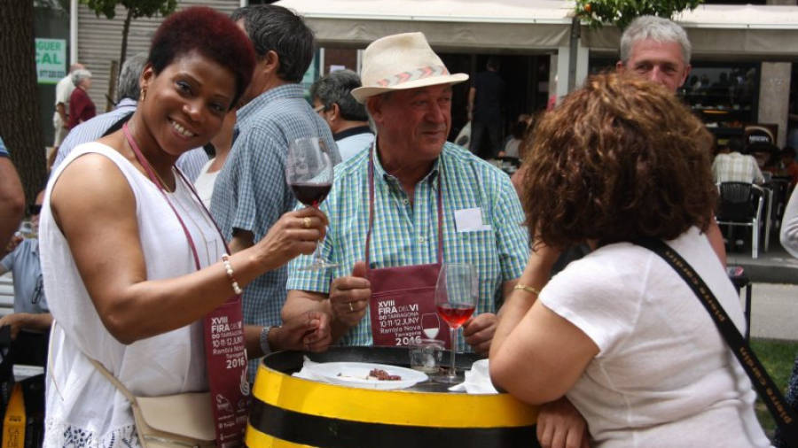 Pla mig de tres persones bevent vi a la Fira del Vi de Tarragona. Foto: ACN