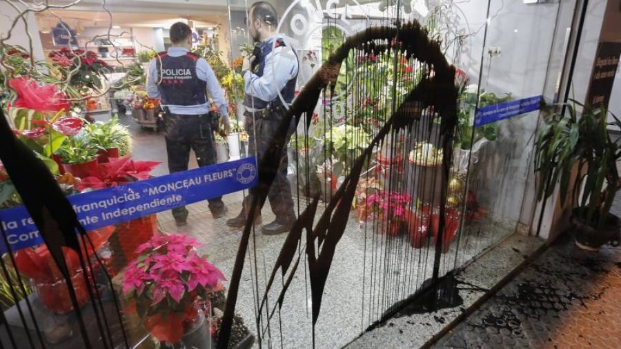 Dos mossos d´esquadra, el pasado miércoles por la noche en la floristería minutos después de ser atacada. Foto: Pere Ferré