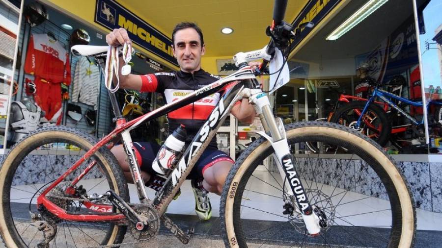 Carni, con su bici y medalla, frente a Cicles Sport Torrente de Reus, donde trabaja. foto: Alfredo González
