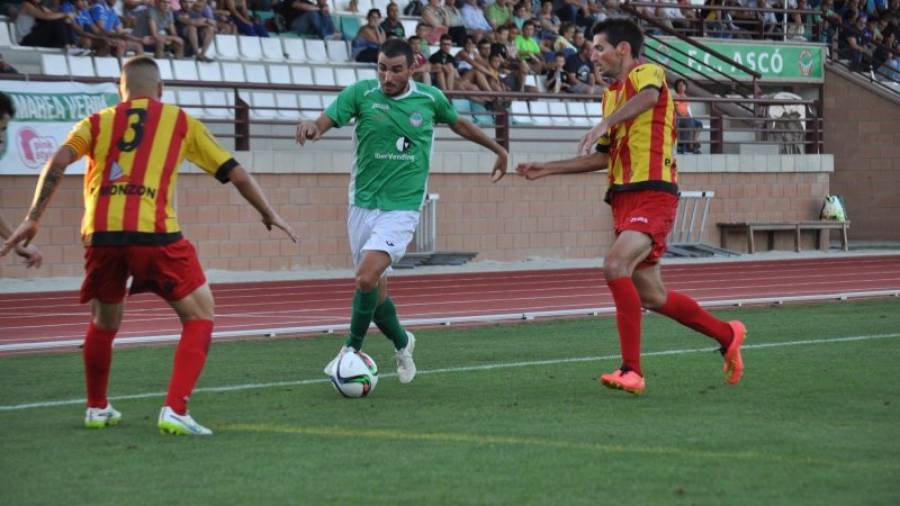 Dos jugadores del Lleida Esportiu intentan detener el avance de un futbolista del Ascó, durante el partido de ayer. Foto: Iris Solà