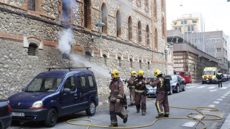 Los bomberos sofocan las llamas que salían por una de las ventanas que dan a la calle August. Foto: Pere Ferré