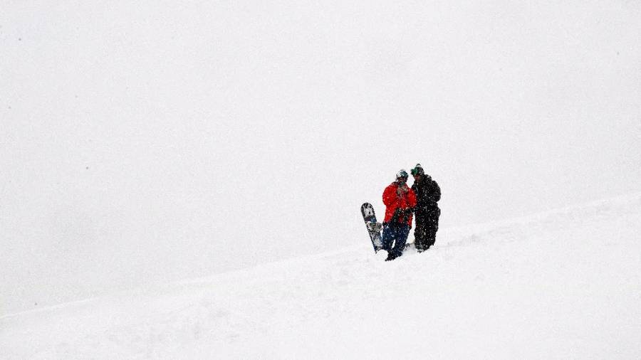 Dos personas se disponen a hacer snowboard en el parque Cerro del Tío Pío en Vallecas&nbsp;(EFE)