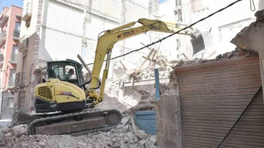 La máquina excavadora trabajando ayer en la retirada de escombros de la casa derruida. Foto: alfredo gonzález