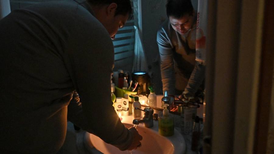 Andrei Agaci lavándose las manos iluminado por dos velas. El bloque de pisos dónde vive no tiene luz desde hace diez días. FOTO: A. GONZÁLEZ