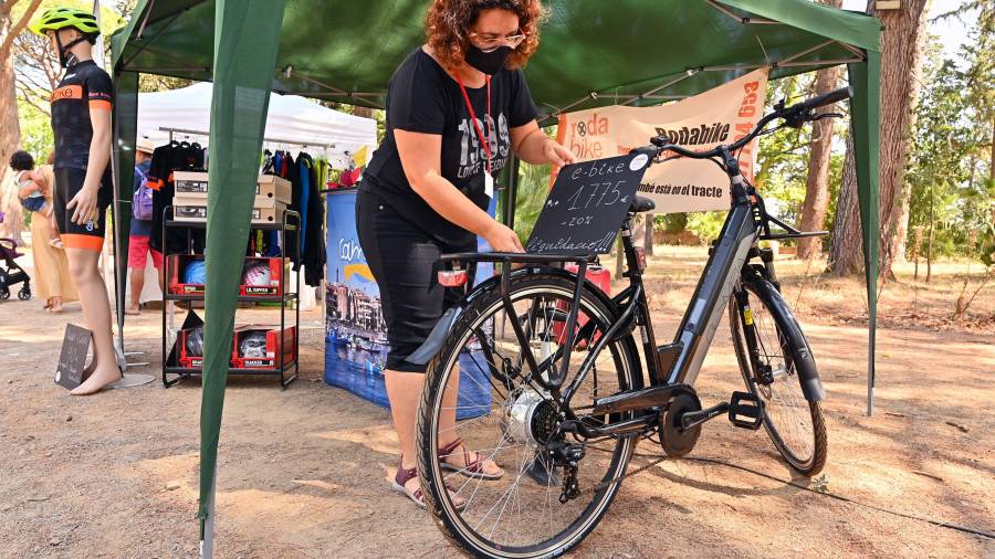 Laura Moreno, de Rodabike Cambrils, coloca el cartel de descuento sobre una de sus bicicletas eléctricas. FOTO: ALFREDO GONZÁLEZ