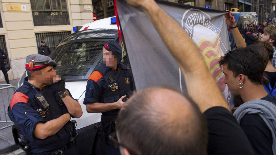 Un grupo de estudiantes de un colectivo antifascista, frente a agentes de la Polic&iacute;a Nacional, ayer en Barcelona. Foto: enric fontcuberta/efe