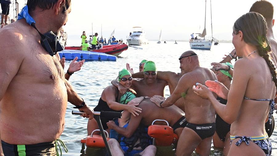 Jordi Cervera abraza a Siscu Morell rodeado de los nadadores. FOTO: Alfredo Gonzáĺez