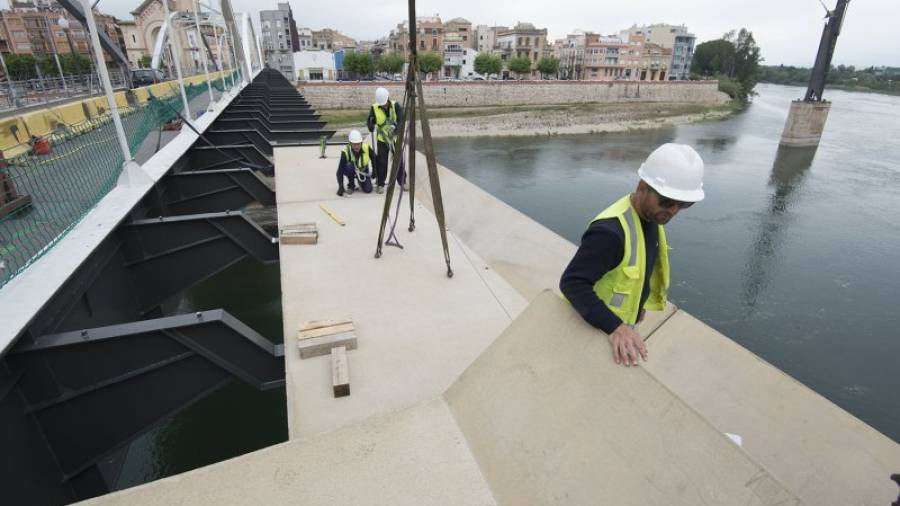 Els operaris instal·lant la passarel·la, aquest dimarts a la tarda al pont de l´Estat de Tortosa. FOTO: JOAN REVILLAS