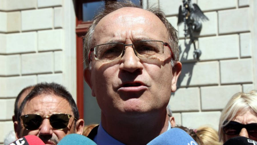 Josep Maria Pujol, advocat del grup municipal d'Ara Reus, davant la porta de l'Ajuntament atenent als mitjans de comunicació. Foto: ACN