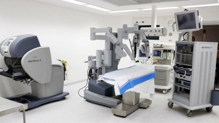 Pla general del nou sistema robòtic 'Da Vinci' instal·lat en un quiròfan de l'Hospital Joan XXIII de Tarragona. D'esquerra a dreta: la consola quirúrgica, el carretó del pacient i la torre de visió. Imatge del 22