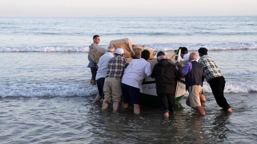 Actors figurants del documental 'Els anys del contraban' fent de vilatans, entrant la barca a mar per rodar una escena. Foto: Dipso Films
