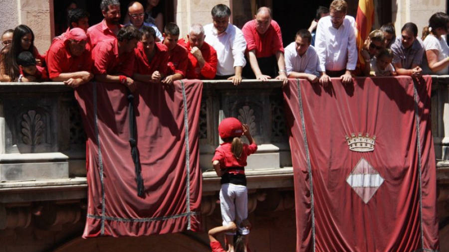 L'enxaneta de la Colla Joves fent l'aleta en el pilar de comiat davant el balcó de l'Ajuntament durant la diada de Sant Joan de Valls. ACN
