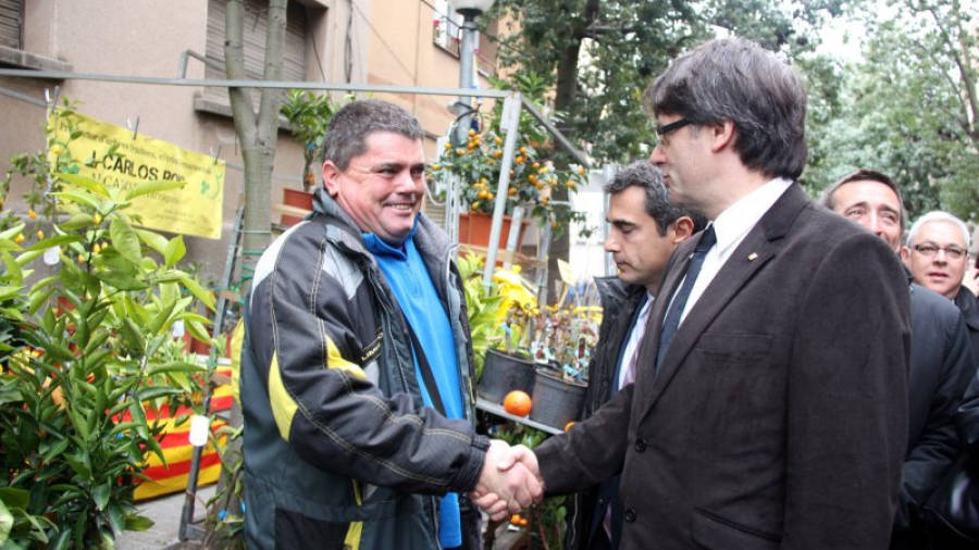 El president de la Generalitat, Carles Puigdemont, saludant un expositor a la Fira de la Candelera de Molins de Rei. Foto: ACN