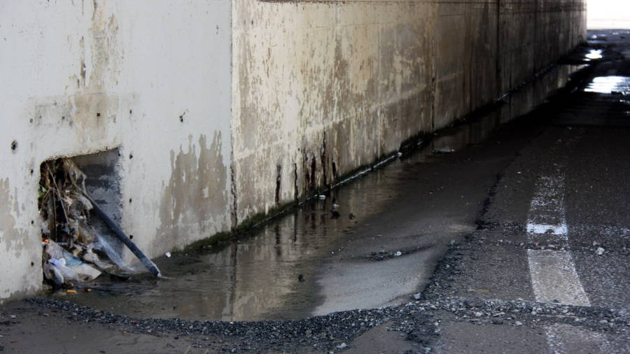 Restes de fang i aigua de la tempesta de la matinada a Tarragona en el pont d'accés a un hipermercat de les Gavarres. Foto: ACN