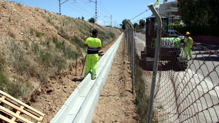 Operaris treballant en la instal·lació de fibra òptica al costat de la via del ferrocarril a Altafulla, aquest dimarts. Foto: ACN