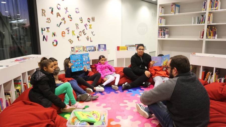 Varios niños, en la zona infantil de la Biblioteca Pere Anguera. FOTO: ALBA MARINÉ