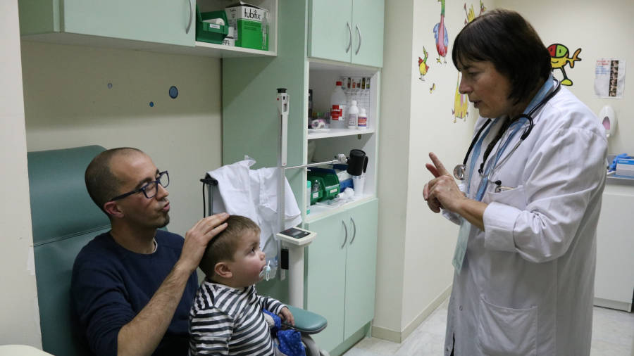 Un nen i el seu pare, en una visita al metge, en una imatge d´arxiu. FOTO: ACN