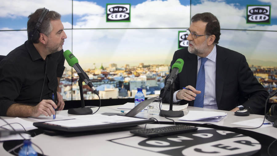 El presidente del Ejecutivo, Mariano Rajoy, junto al periodista Carlos Alsina de Onda Cero. FOTO: DIEGO CRESPO/EFE