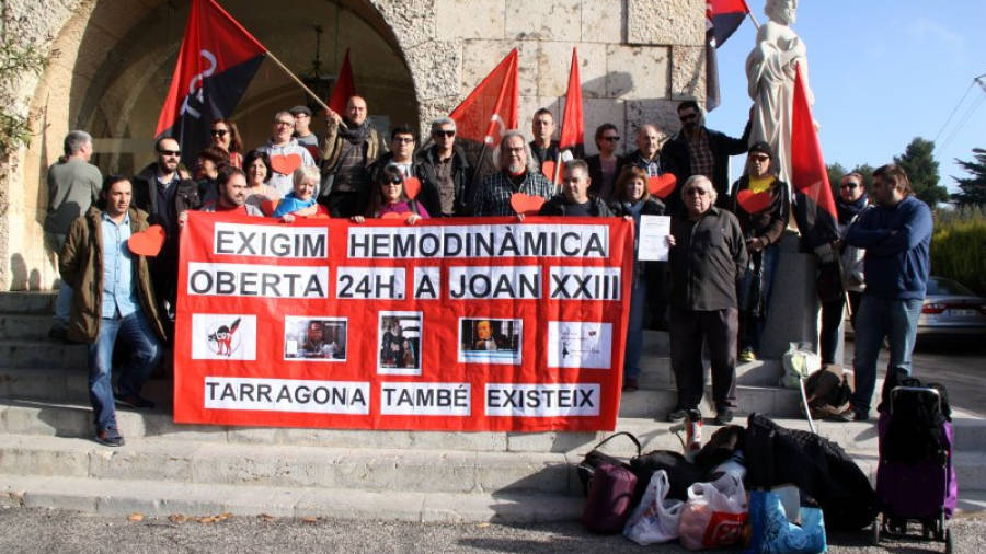 Els convocants de la protesta, a l'exterior de la seu dels serveis territorials de Salut a Tarragona amb una pancarta on s'exigeix l'obertura 24 hores d'hemodinàmica. Foto: ACN
