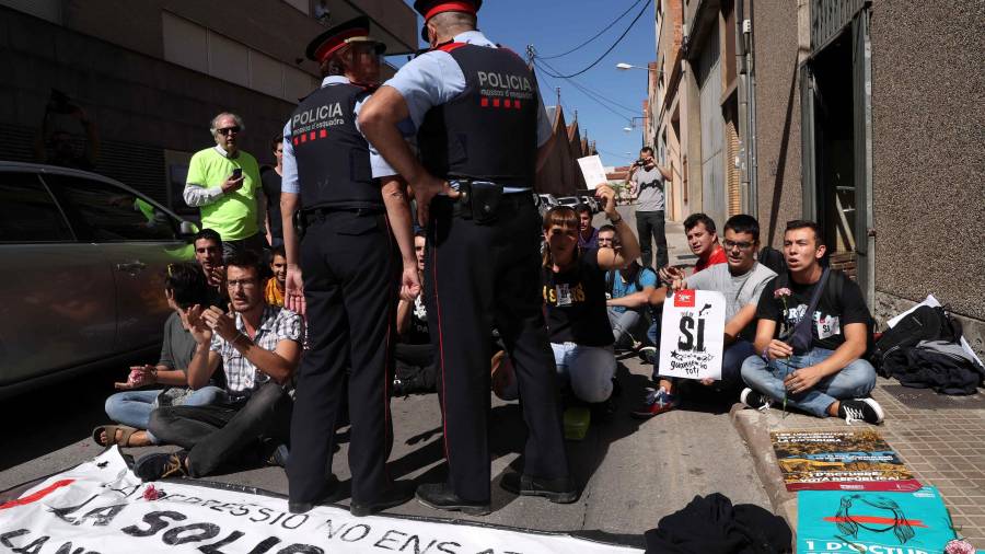 Un grupo de personas realizan una sentada ante la oficina de la empresa de mensajer&iacute;a Unipost en Terrassa. FOTO: EFE