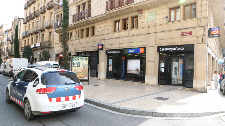 Un coche de los Mossos pasa por delante de la oficina del BBVA-CX atracada, en la calle Sant Joan. FOTO: A. MARINé