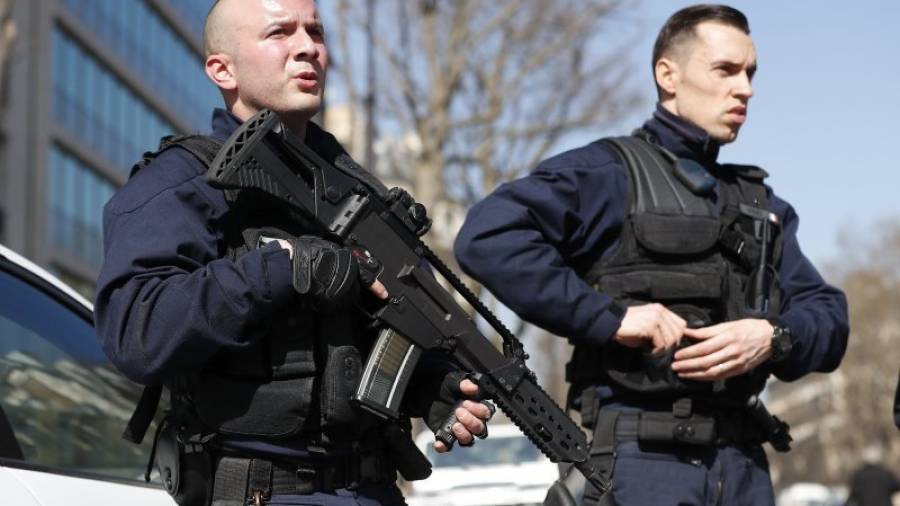 Agentes de policía montan guardia en los alrededores de la sede del Fondo Monetario Internacional (FMI) en París (Francia) después de que un empleado resultase herido al abrir un paquete que contenía un explosivo hoy, 16 de mar