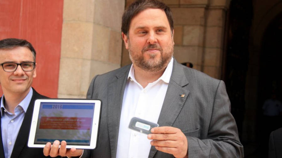 El vicepresident i conseller d'Economia, Oriol Junqueras, mostra el 'pen drive' i una tauleta digital amb els comptes, amb el títol 'Pressupostos amb sentit d'estat'. Foto: ACN