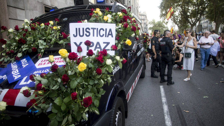 Un furg&oacute;n de los Mossos cubierto de flores. Numerosos ciudadanos mostraron de nuevo su agradecimiento a la polic&iacute;a catalana. Foto: EFE.