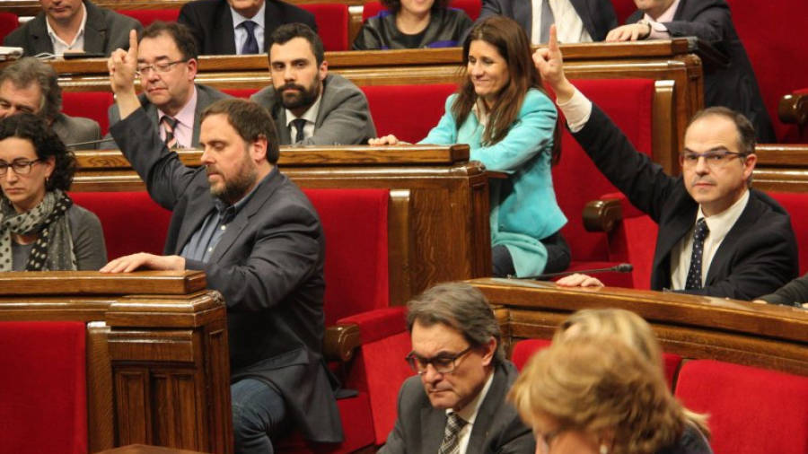 Oriol Junqueras (ERC) i Jordi Turull (CiU), marquen la votació favorable als pressupostos per a 2015, amb Artur Mas votant. Foto: ACN