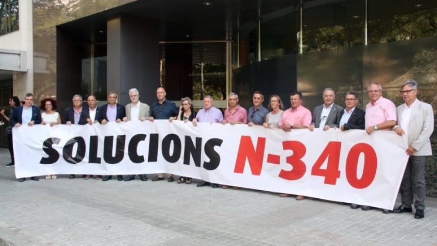 Los alcaldes y representantes del Camp de Tarragona y Terres de l´Ebre, exhibiendo una pancarta reivindicativa en la puerta de la Conselleria. Foto: ACN