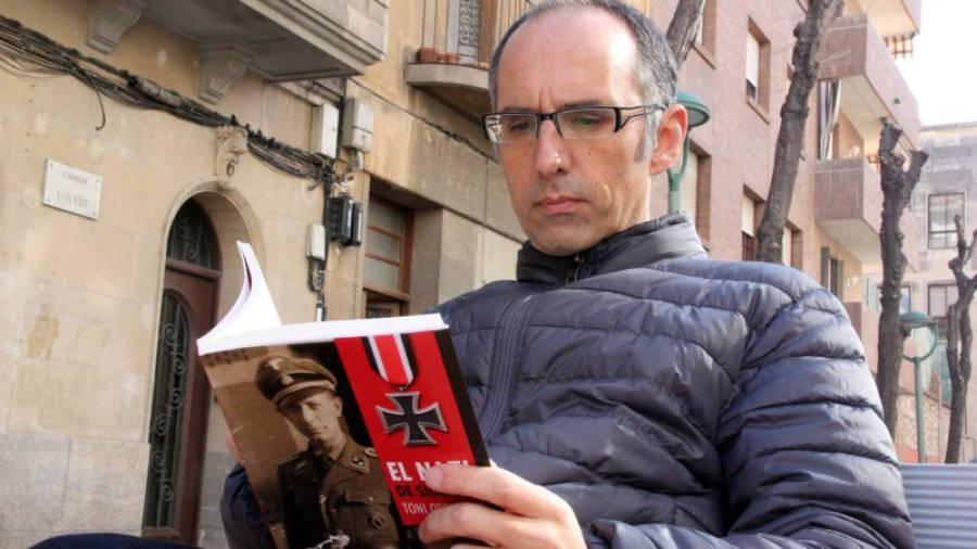 Pla mig del periodista i escriptor Toni Orensanz fullejant el seu llibre 'El nazi de Siurana'. Imatge del 4 de febrer de 2016 a Tarragona. Foto: ACN