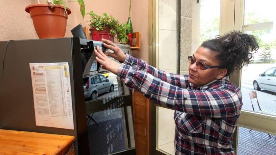 La propietaria de La Tasca muestra los destrozos realizados en la máquina de tabaco durante el robo sufrido el pasado lunes. Foto: Alba Mariné