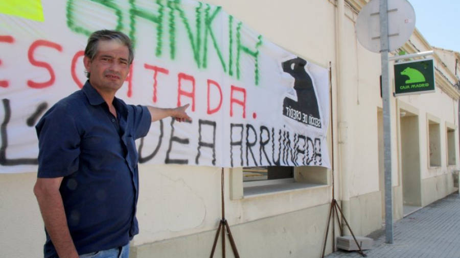 L'empresari aldeà Javier García Vivo, afectat i imputat en el cas, durant una protesta a les portes de la façana de la secció de crèdit de la Cooperativa de l'Aldea amb pancartes contra Bankia i el logotip de l'entitat.