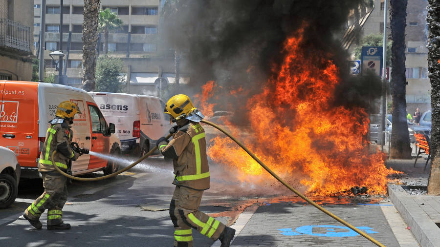 Los bomberos. apagando el fuego de los contenedores que quemaron el viernes en la calle Ample, Foto: A.G.