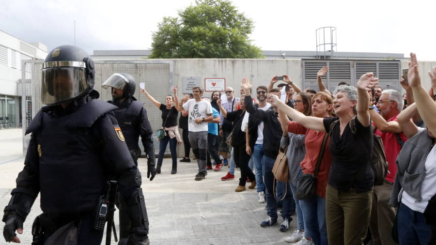 Pla obert de ve&iuml;ns del barri de Sant Salvador de Tarragona acomiadant els agents de la policia espanyola que han irromput a l'institut del barri. FOTO: ACN 