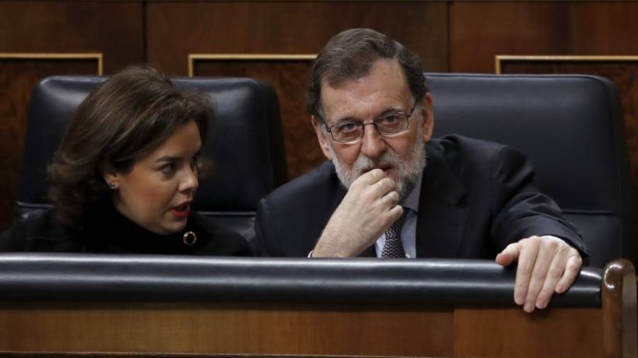 El presidente del Gobierno, Mariano Rajoy, y la vicepresidenta, Soraya Saénz de Santamaría, conversan en sus escaños poco ante del inicio de la sesión de control al Gobierno, que se celebra hoy en el Congreso de los Diputados.