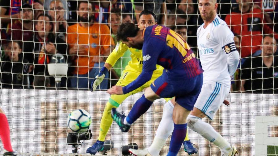 El delantero argentino del Barcelona Lionel Messi (c) se dispone a conseguir el segundo gol de su equipo ante el Real Madrid en un partido de liga.
