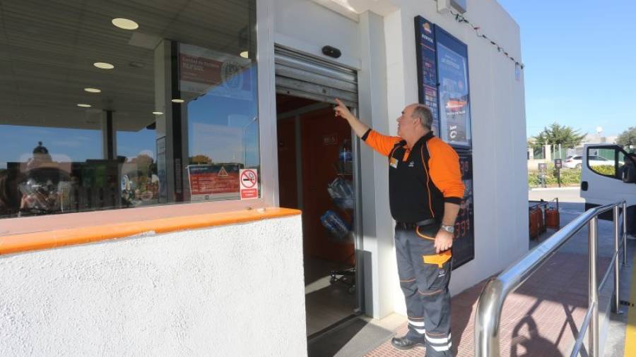 Un trabajador de la gasolinero enseña la puerta metálica que intentaron forzar los ladrones en la madrugada del sábado. FOTO: ALBA MARINÉ